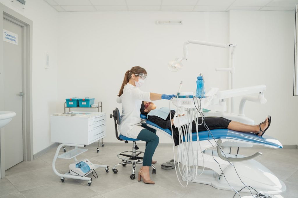 A dentist attends to a patient in a modern dental clinic with advanced equipment.